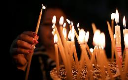 Candele accese a scrocco e il parroco toglie i lumini