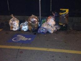 Rifiuti nel parcheggio disabili
