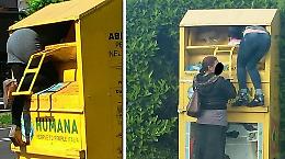 Rovistano nel cassone in cerca di vestiti