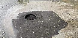 Una voragine nell’asfalto, strada parzialmente transennata