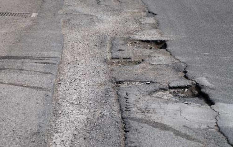 Strada dissestata con buche