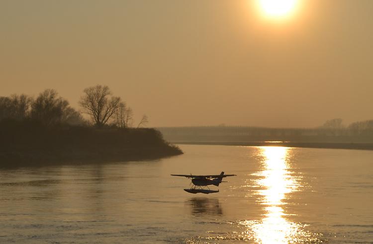 Idrovolante in ammaraggio sul tratto di Po cremonese al tramonto