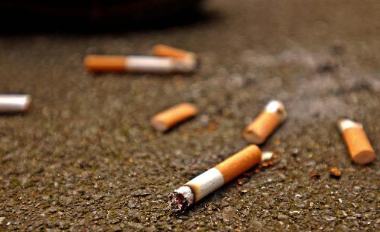 Fumano e gettano i pacchetti per strada: un doppio errore