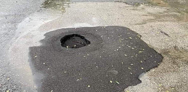 Una voragine nell’asfalto, strada parzialmente transennata